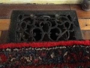 An iron grate in a parquet wood floor