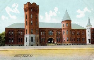 A postcard of a color drawing of a long, 2-story building with many windows and two turrets.