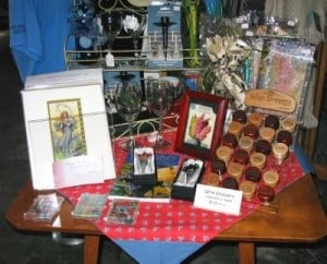 A display on a table of framed prints, wooden wine bottle stoppers and magnets.