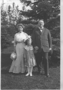 woman, little girl, and man standing outside in front a tree