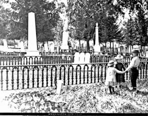 Black and white photo of three children playing in Washington Street Cemetery