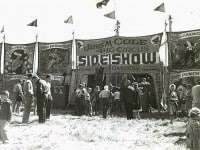 People standing at the entrance to the James M. Cole Big Circus Sideshow.