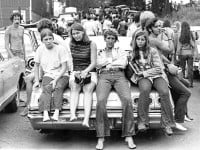 young-people-in-jeans-sitting-on-a-car-trunk-at-woodstock-in-1969