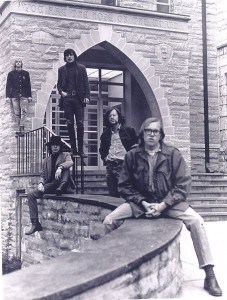 Black and and white image of the band Lost and Found. Members of the band are posed outside of a building