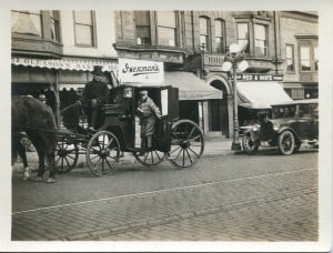 Black and white photography of a horse drawn delivery service carriage