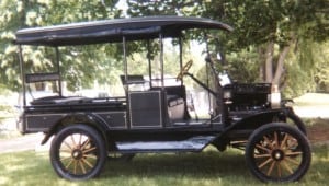 Colored photo of a 1916 Model T ford Canopy Express underneath a tree.