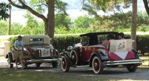 Two hupmobiles parked outsdoors