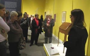 people standing around a desk in a exhibit case