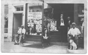 men standing and sitting outside a store front