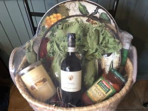 Basket filled with jars, wine, and plates
