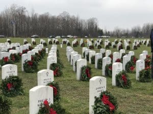 A cemetery with wreaths in front of every headstone