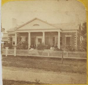 one-story, cobblestone house behind a fence