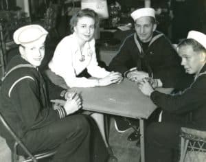 three soldiers and a woman sitting around a table playing cards