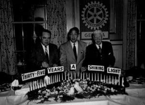 3-men-standing-with-candles-&-sign-35-years-a-shining-light