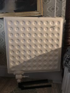 square shaped  radiator on a stand with rows of circles