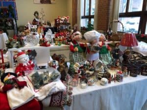 A table display of Santa figures, snowmen and Christmas canles.