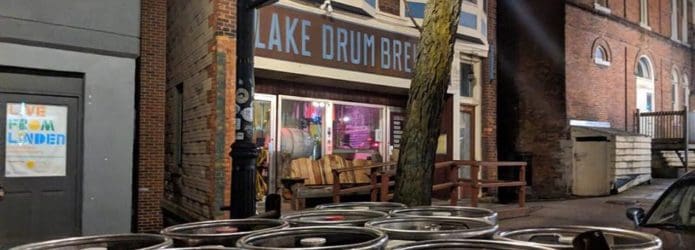 a tree and kegs in front of a store front