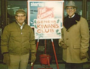 Two Older Men In Coats Ringing Bells For Salvation Army