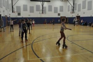 Children Rollerskating In School Gym