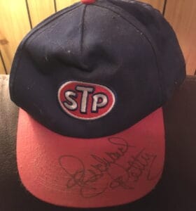 Blue baseball hat with a red visor and "STP" patch on the front.