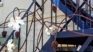 Copper sculpture of a grapevine twisting around fire escape steps.