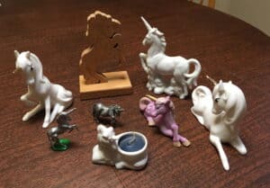 A collection of unicorn figurines that are made from a variety of materials