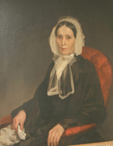 Painting of woman seated in a red chair