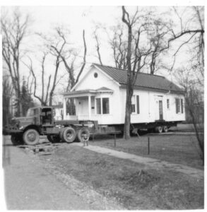 single story house being towed by a truck