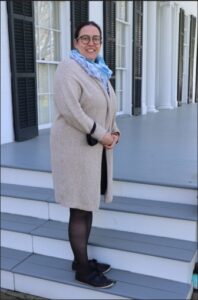 woman standing on a the steps of a porch