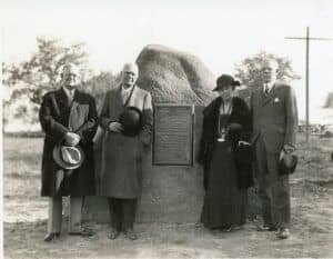 three men and a woman standing around a boulder
