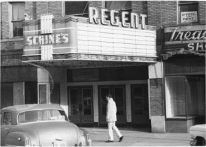 A car parked in front of the Regent Theater
