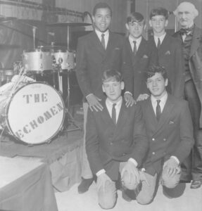  Five men posed next to a drum set.