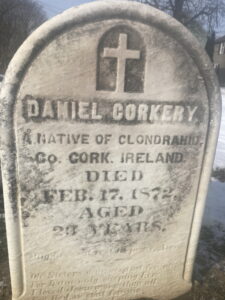 Marble headstone with a cross and inscription.