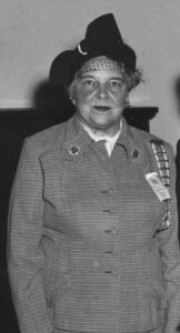 woman wearing a suit and hat.