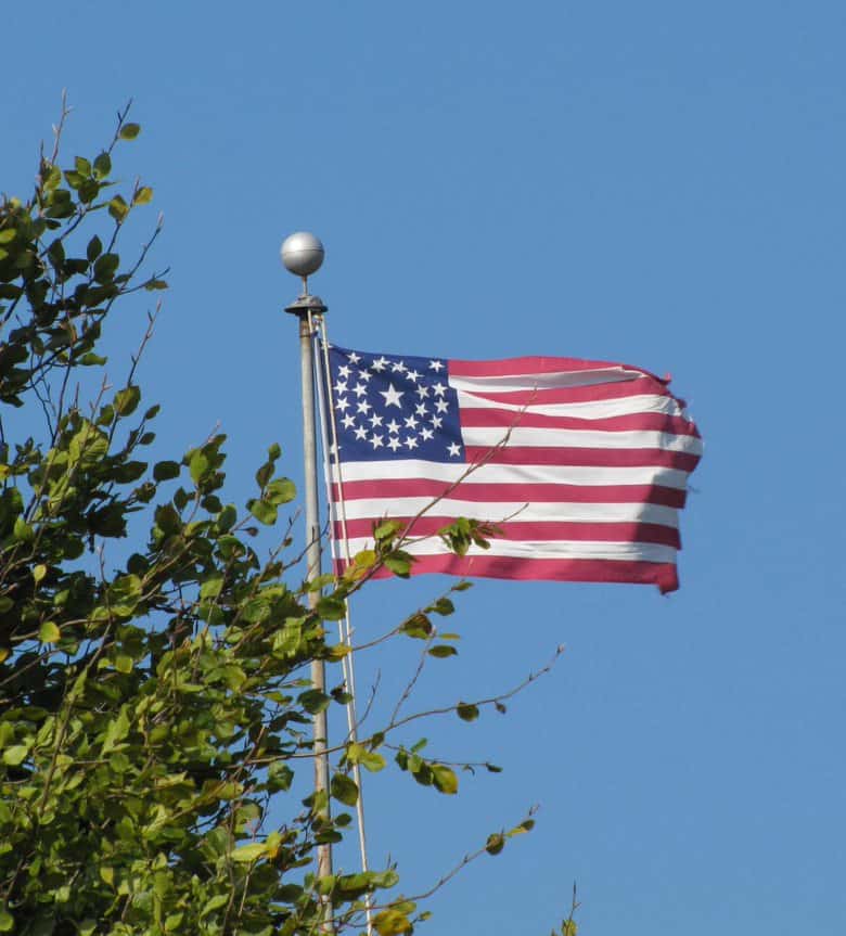 An American flag with 33 stars arranged in two concentric circles flying on a flagpole