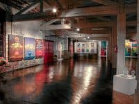 Art show in a large room with a wooden floor