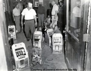 Group of men examining slot machines.
