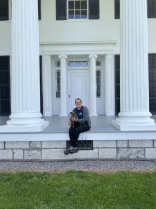 woman and dog sitting on the front porch of Rose HIll.