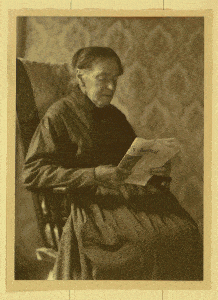 Rhoda Palmer siting in a chair and reading 