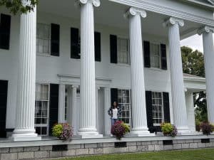 Young woman standing on the the front porch of Rose Hill Mansion