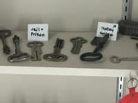 A shelf of old keys including several for jails and one for a trolley.