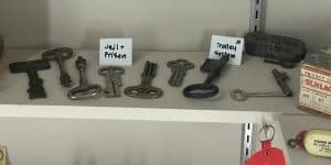 A shelf of old keys including several for jails and one for a trolley.