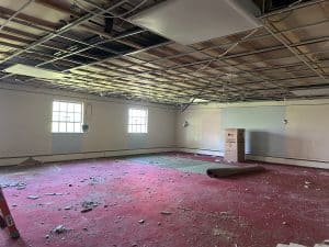 The Hucker gallery with part of the carpet torn up and ceiling removed.