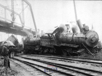 A NYC & HR train engine crashed off tracks under a railroad bridge.