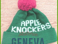 Green knit cap with red pom and white letters from Appleknocker Drum & Bugle Corp