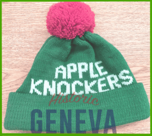 Green knit cap with red pom and white letters from Appleknocker Drum & Bugle Corp