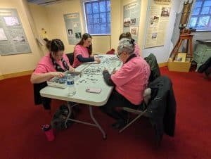 People around a table doing a jigsaw puzzle.