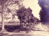 black and white photo of dirt road with cinder path to left