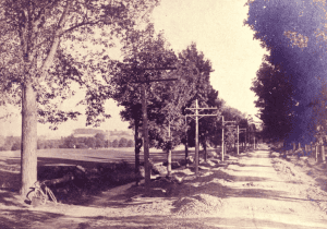 black and white photo of dirt road with cinder path to left