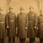 Five men in old-fashioned constable uniforms with billy clubs.